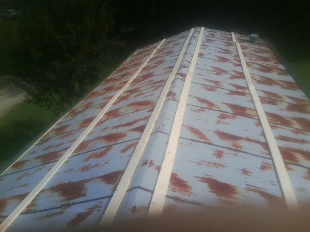 Rusted metal roof panels with new wood purlins before replacement — Storm Damage Roof Repair in Mondamin by Roofing Brothers