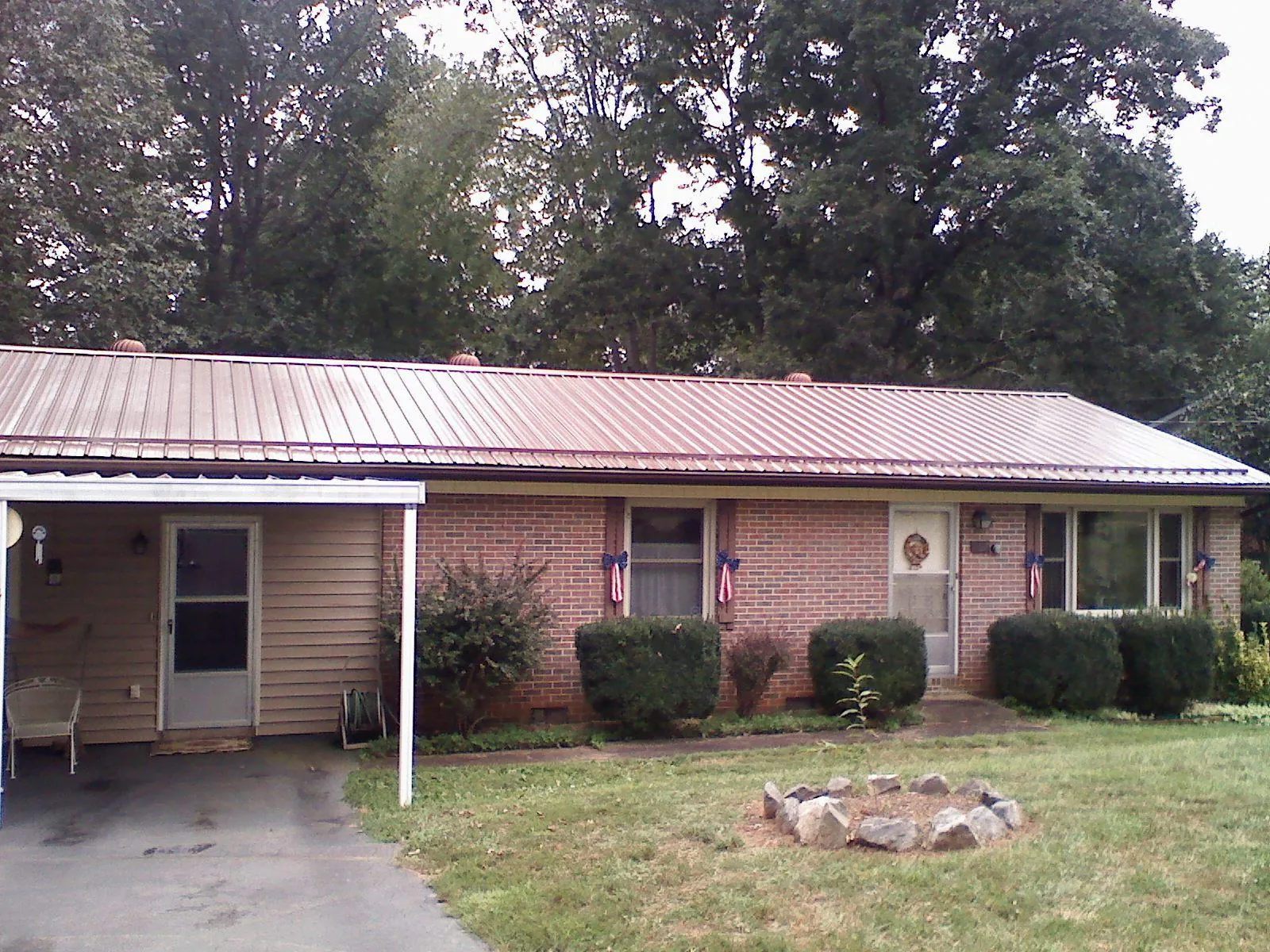 Bronze metal roof and carport on a brick ranch home — Roof Repair work by our crew in Mondamin